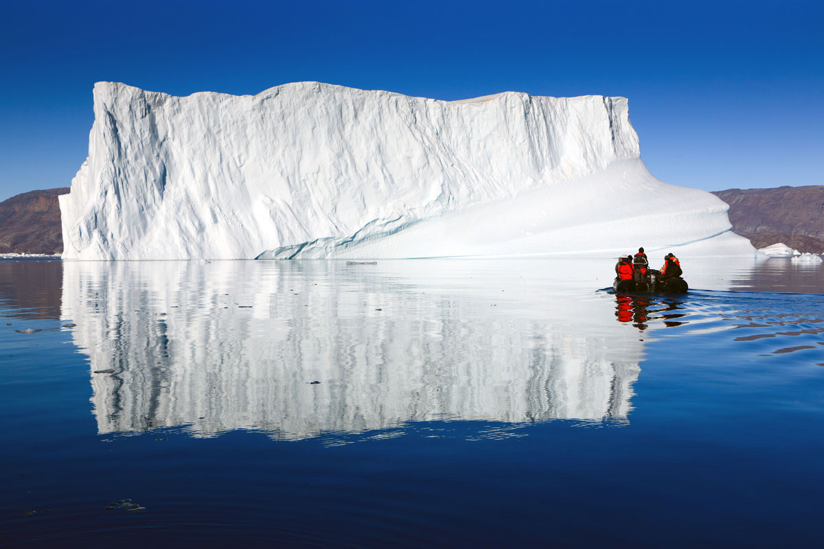Cruising between the icebergs at Røde Ø, Scoresby Sund, Greenland. Henk Meijer / Alamy Stock Photo